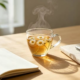 A calming glass of herbal tea next to an open notebook on a serene wooden desk, illustrating stress reduction for leaky gut healing.
